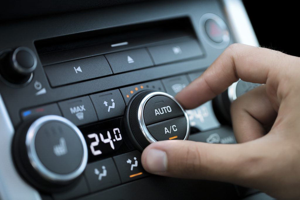 Une personne change la climatisation de sa voiture à 24°. pénurie de carburant 