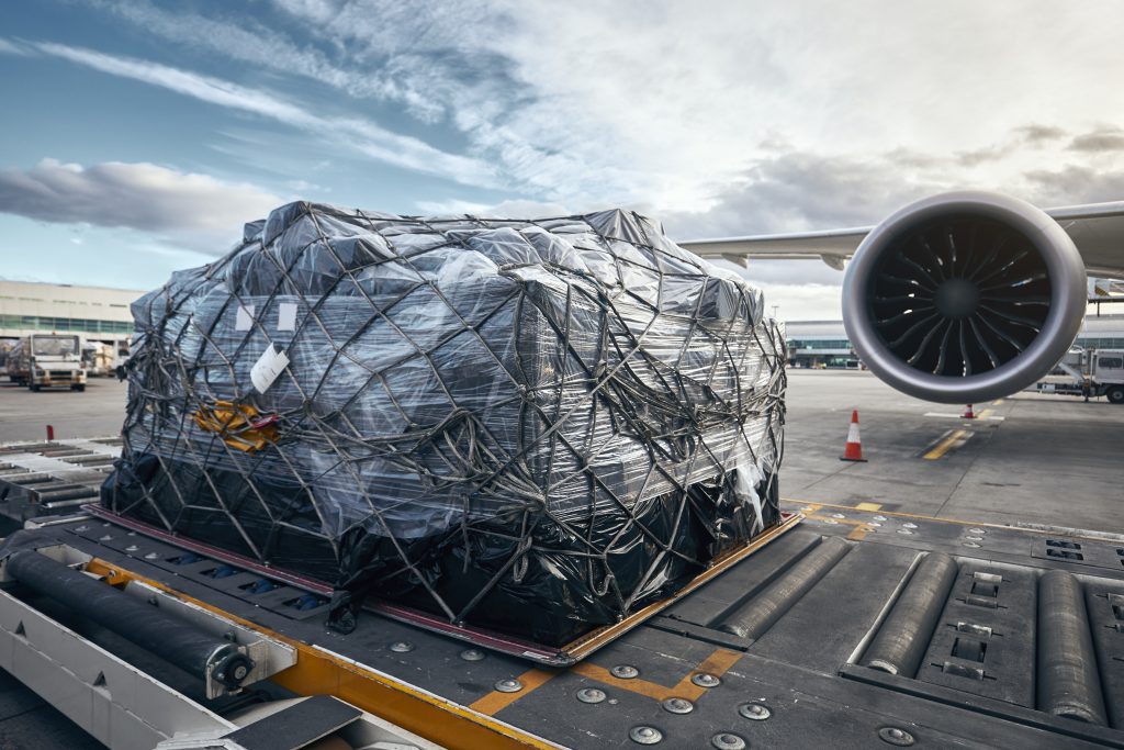 Préparation avant le vol. Chargement d'un conteneur de fret sur l'avion.